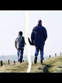 A father and son walking together in a photo that has been ripped apart