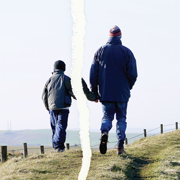 A father and son walking together in a photo that has been ripped apart