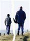 A father and son walking together in a photo that has been ripped apart