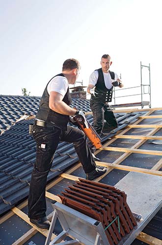 two men putting tiles on a roof