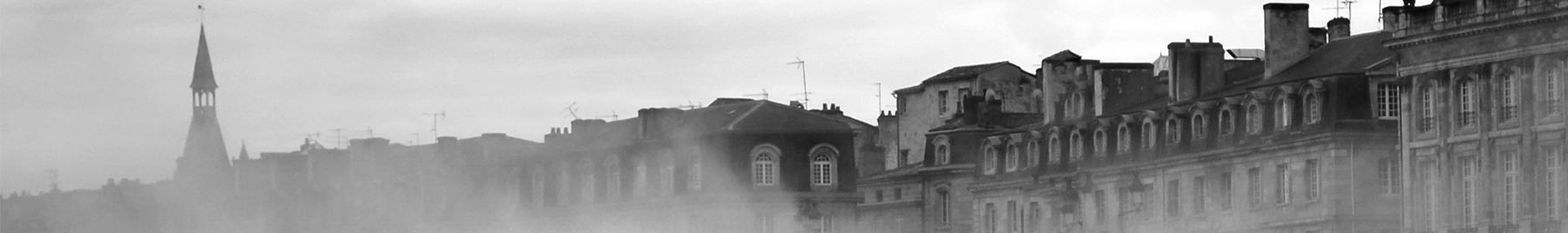 black and white photo of buildings in the mist