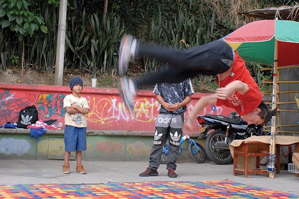 A breakdancer performs on the sidewalk.