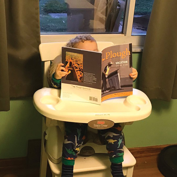 a toddler looking at the Plough Quarterly