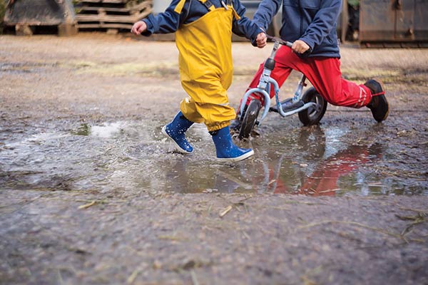 children splashing in a puddle