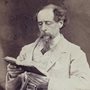 A photo of Charles Dickens reading a book