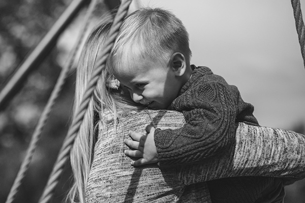 black and white photograph of a little boy hugging his mother