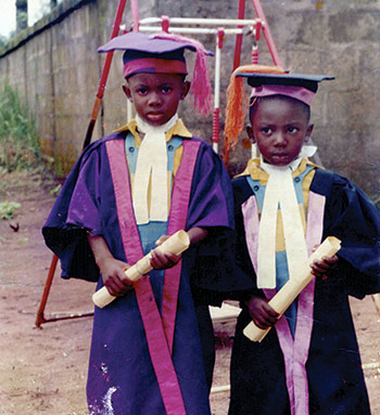 two young boys holding diplomas