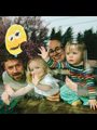 a father and mother and two daughters, photographed at their living room window