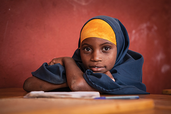 portrait of a young school girl seated at a desk