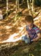 boy in a striped shirt playing in a sunny forest