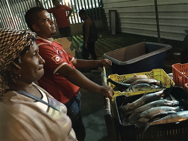 two people selling fresh fish