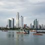 photo of boats in a bay with skyscrapers in the background