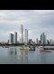 photo of boats in a bay with skyscrapers in the background