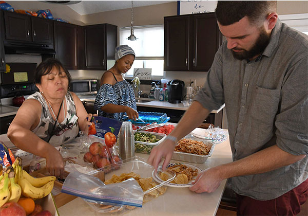 people preparing a meal in a sunny kitchen