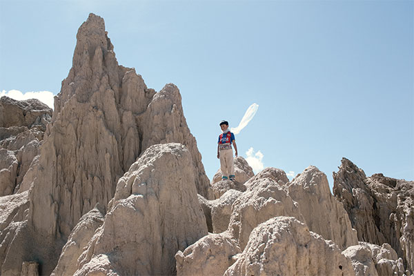 photograph of an Aymara boy standing on jagged rocks