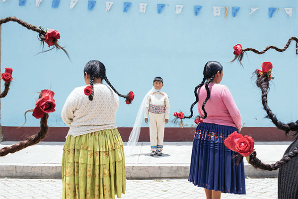 fotografía de un grupo de mujeres aimaras con rosas en las trenzas