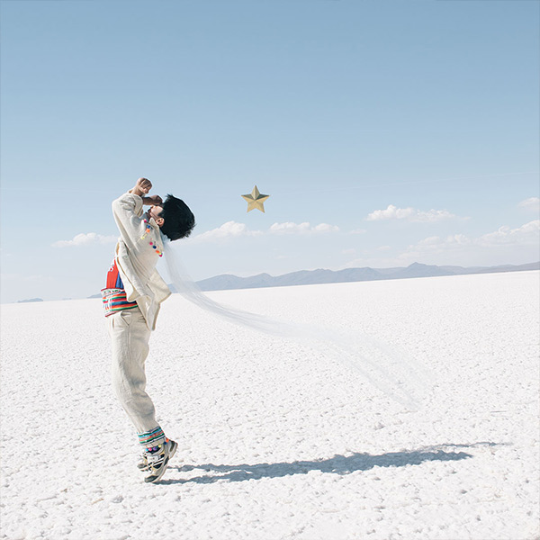 boy in white dancing on a flat white plain: reenactment of an image from The Little Prince