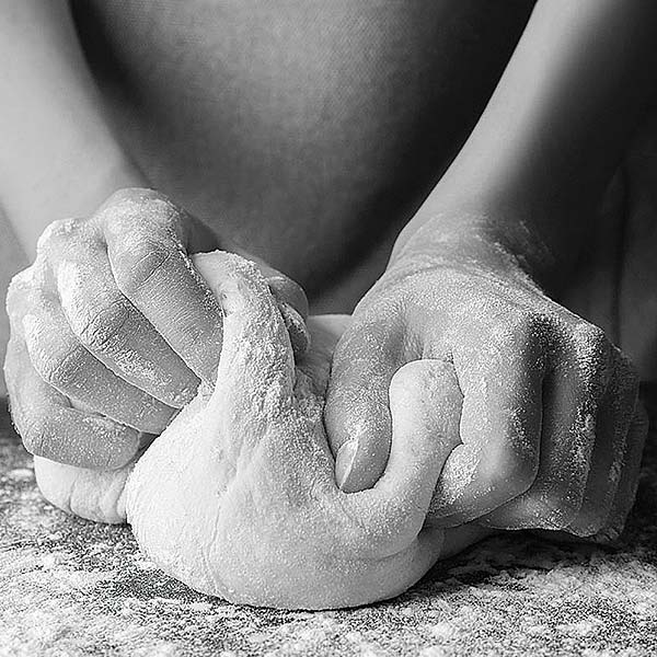 person kneading dough