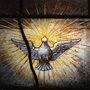 stained glass artwork of a dove surrounded by light