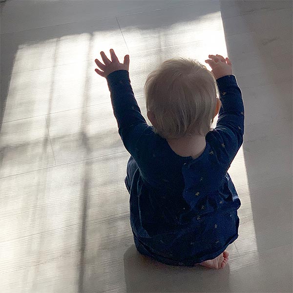 foto de bebe bailando en la luz del sol