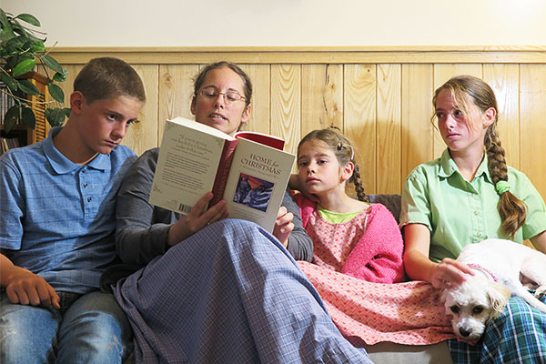 mom reading Christmas stories to her three kids