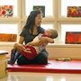 physical therapist holding a child wearing braces in a sunny room