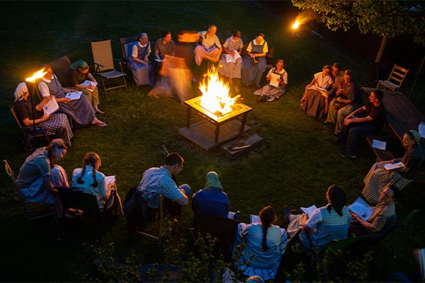 people singing around a campfire