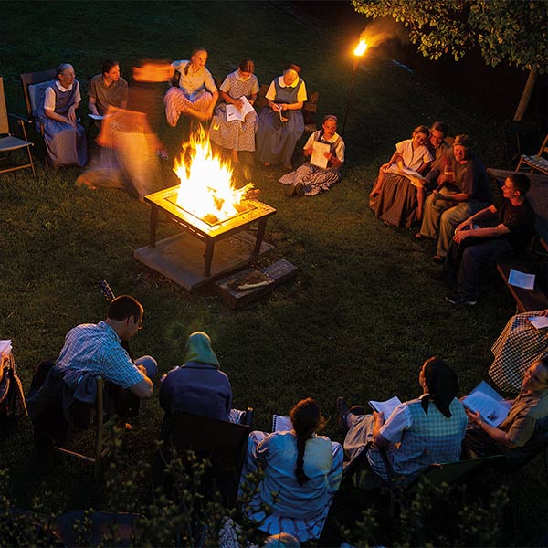 people singing around a campfire