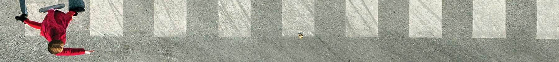 overhead view of a young woman in red on a crosswalk