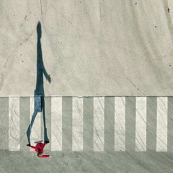overhead view of a young woman in red on a crosswalk