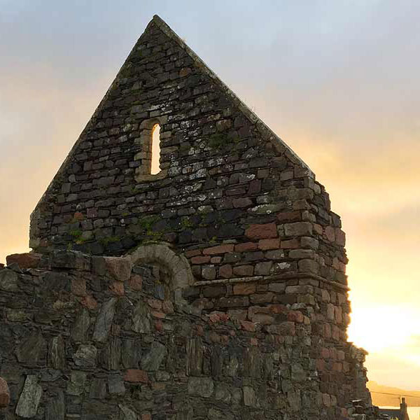 ruins of an old church backlit by the sunrise