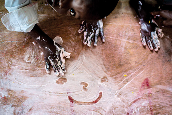 a kid drawing a smiley face in soap bubbles