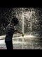 a boy playing in a fountain of water