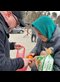 man giving bread and oranges to an older woman in a teal headscarf
