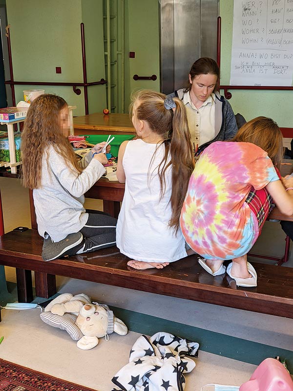 the author helping children with arts and crafts at a center for refugee children