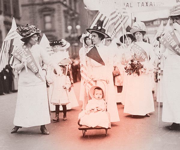 old photograph of suffragettes, one of them pushing a baby in a stroller