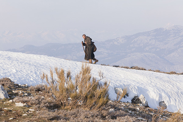 a man walking up a snow covered mountain