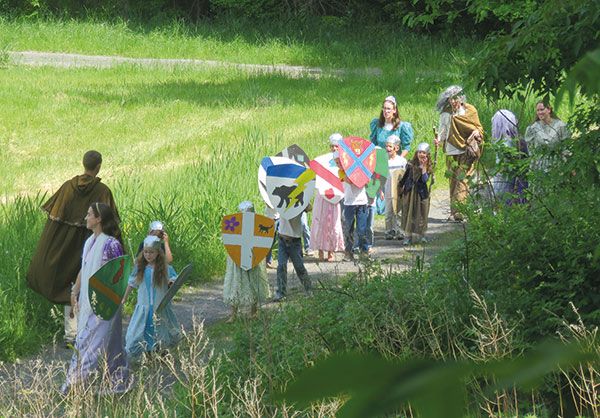 kids dressed as knights and ladies walking along a path