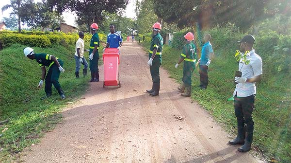 people collecting trash along a dirt road