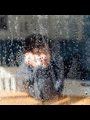 photo of a child looking through a rain covered window