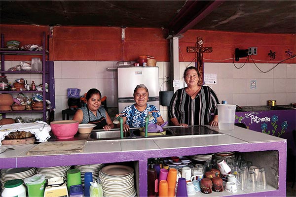 three women standing at a kitchen counter