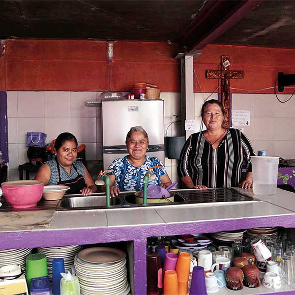 three women standing at a kitchen counter