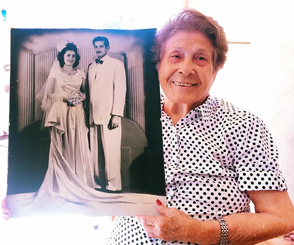 smiling old lady holding a wedding photo