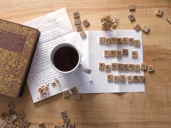 scrabble pieces, letters and a cup of coffee on a wooden table