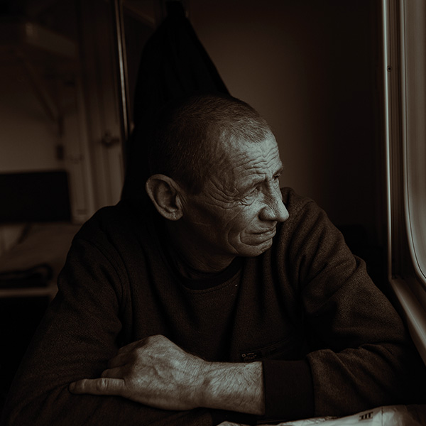 an elderly man looking out of a window