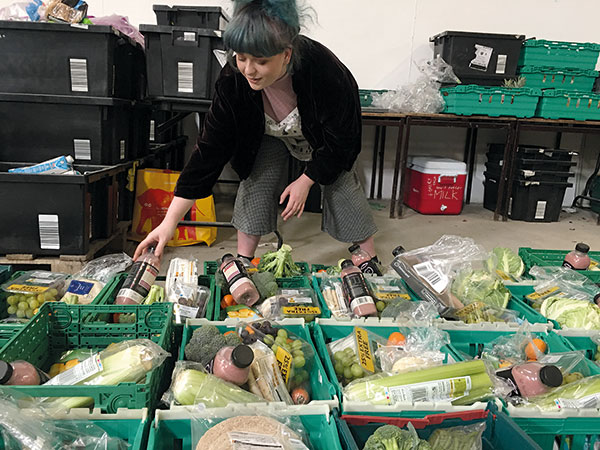 a woman sorting food into crates