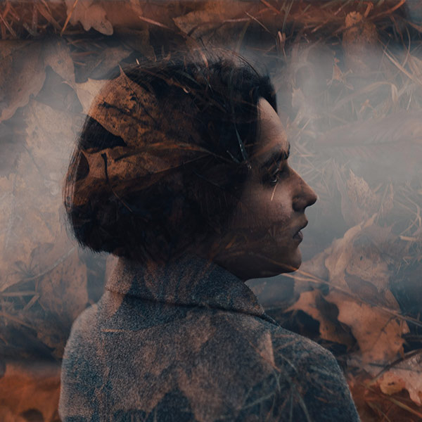 photo of a woman against a leafy background