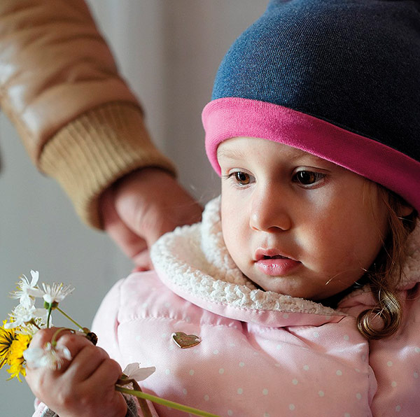 a little girl holding a fistful of flowers