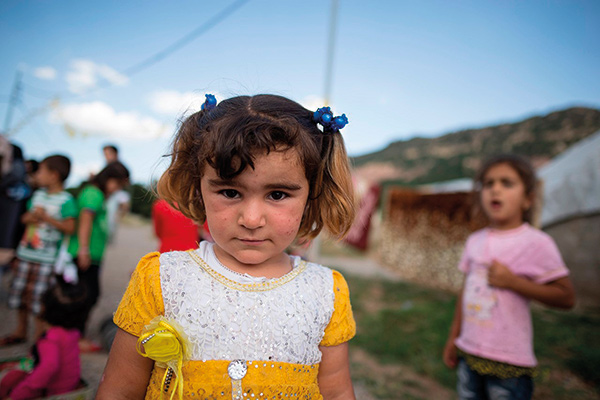 portrait of a refugee girl in a white and yellow dress