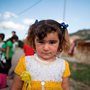 portrait of a refugee girl in a white and yellow dress